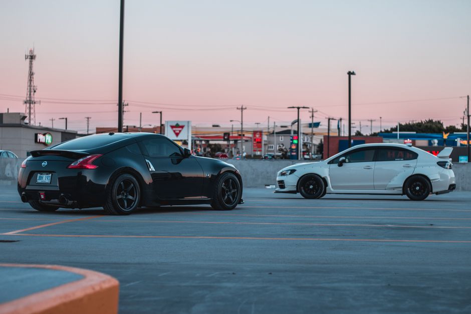 Stylish black and white sports cars parked at sunset