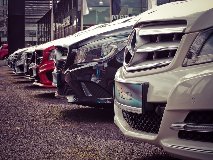 Luxury cars lined up at an outdoor dealership