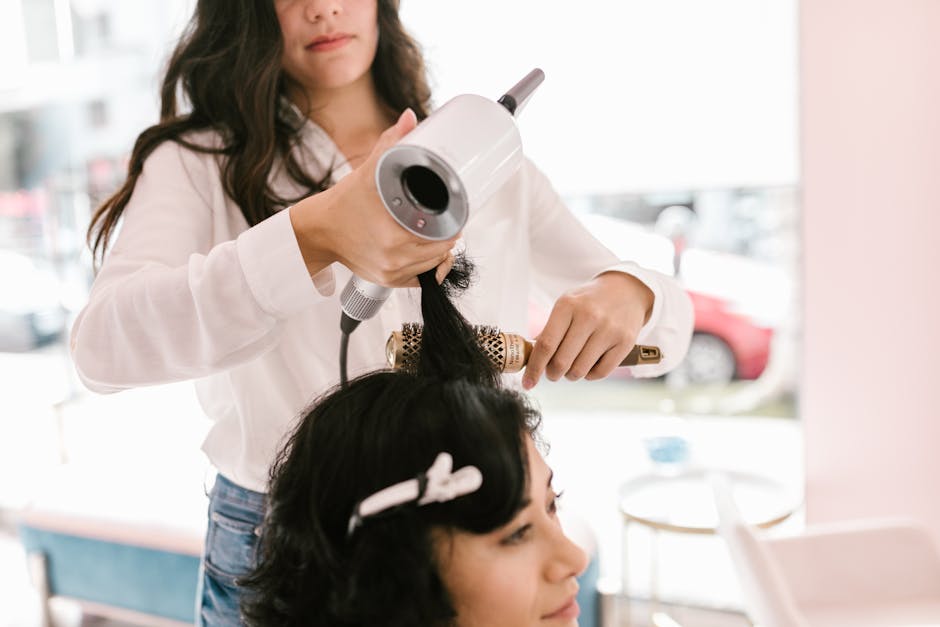 Woman getting her hair styled by a professional hairdresser in a chic modern salon.